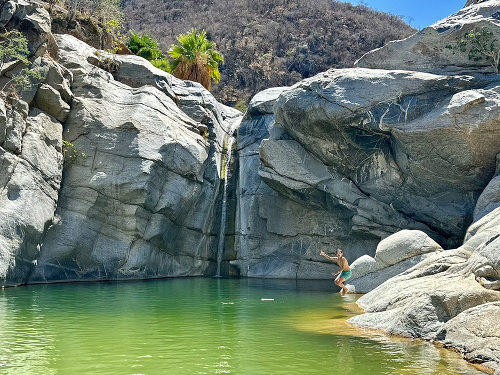 Playing on rocks around the Sol de Mayo waterfall at Canon de la Zorra (Fox Canyon) Baja California Sur, Mexico.