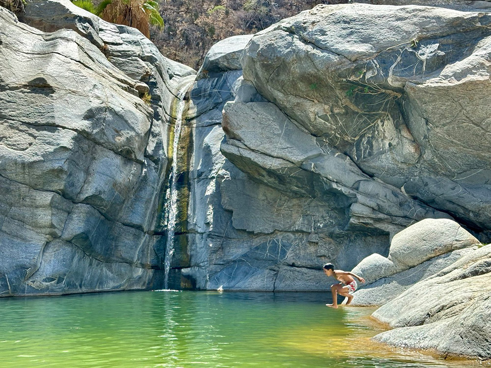 Playing on rocks around the Sol de Mayo waterfall at Canon de la Zorra (Fox Canyon) Baja California Sur, Mexico.
