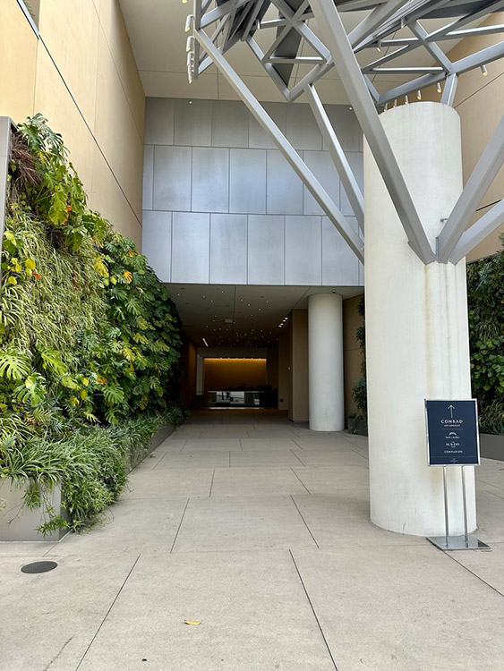 A green wall outside the entrance of the Conrad Los Angeles hotel, California.
