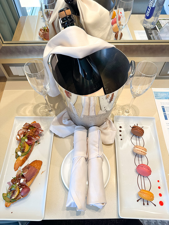 Welcome amenities on board the Holland America Line MS Rotterdam - a bottle of champagne, charcuterie and macarons.