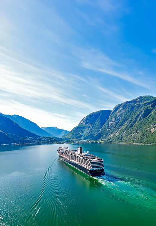 The MS Rotterdam, a Holland America Line cruise ship, sailing through a Norwegian Fjord.