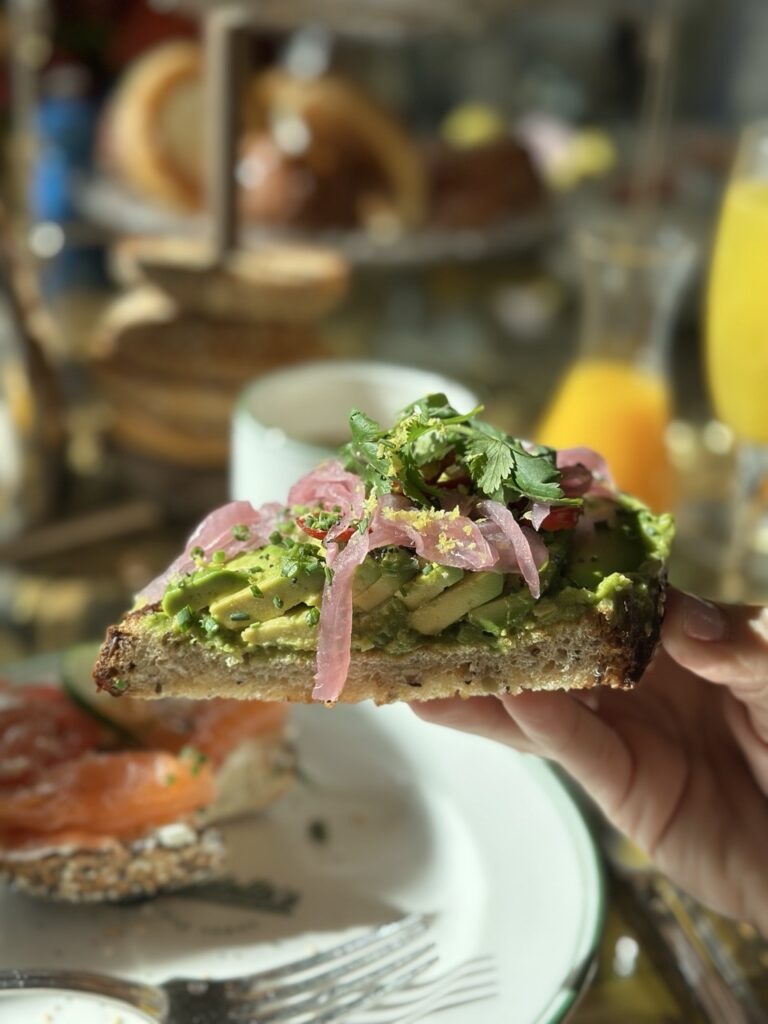 A slice of avocado toast made with home-made bread and garnished with herbs and pink pickled onions. Part of brunch at the Garden Table at the Bellagio, Las Vegas.