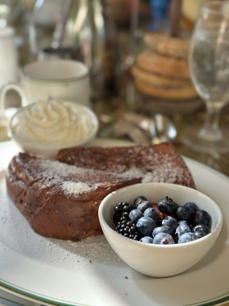 A sumptuous slice of French toast, sprinkled with powdered sugar and served with whipped cream and fresh berries. Part of brunch at the Garden Table at the Bellagio, Las Vegas.