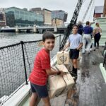 Ashley Wali's sons prepare to throw replica tea chests into the harbor at the Boston Tea Party Museum in Boston, Massachusetts.