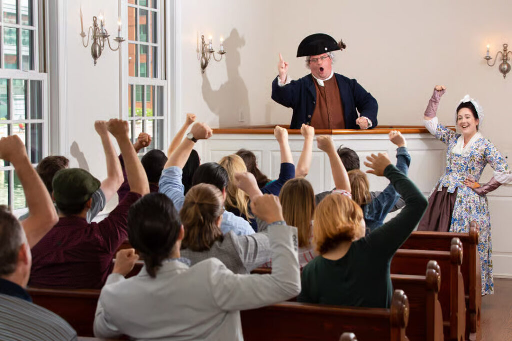 Taking part in a town meeting at the Boston Tea Party Museum in Boston, Massachusetts.