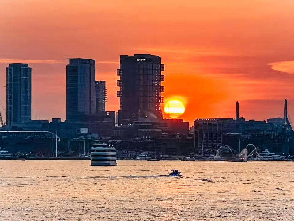 A boat sails across Boston Harbor on a sunset Boston Harbor cruise.