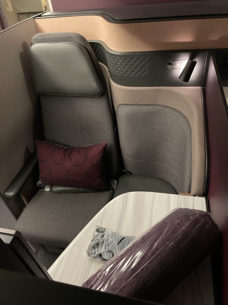 A comfortable pillow and blanket in the Business Class Q-Suite on board a Qatar Airways flight.