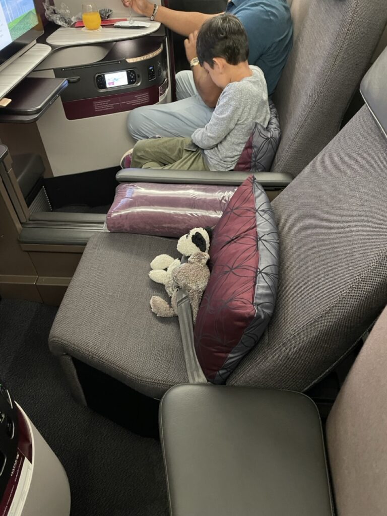 Ashley Wali's younger son's stuffies securely strapped into the Business Class Q-Suite on board a Qatar Airways flight.