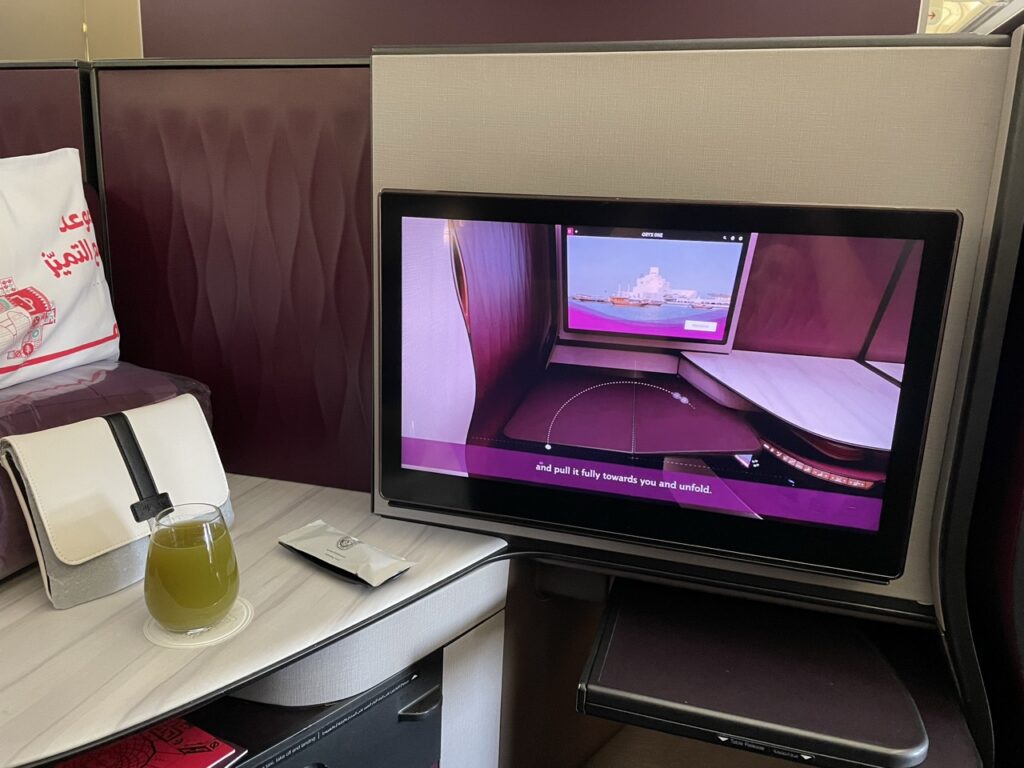 A high-resolution 21" touchscreen entertainment system in the Business Class Q-Suite on board a Qatar Airways flight.