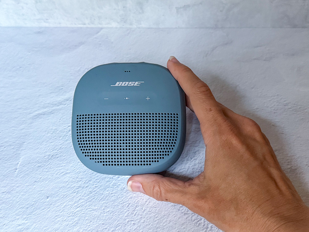 Bose SoundLink Bluetooth speaker being held in a hand for size comparison.